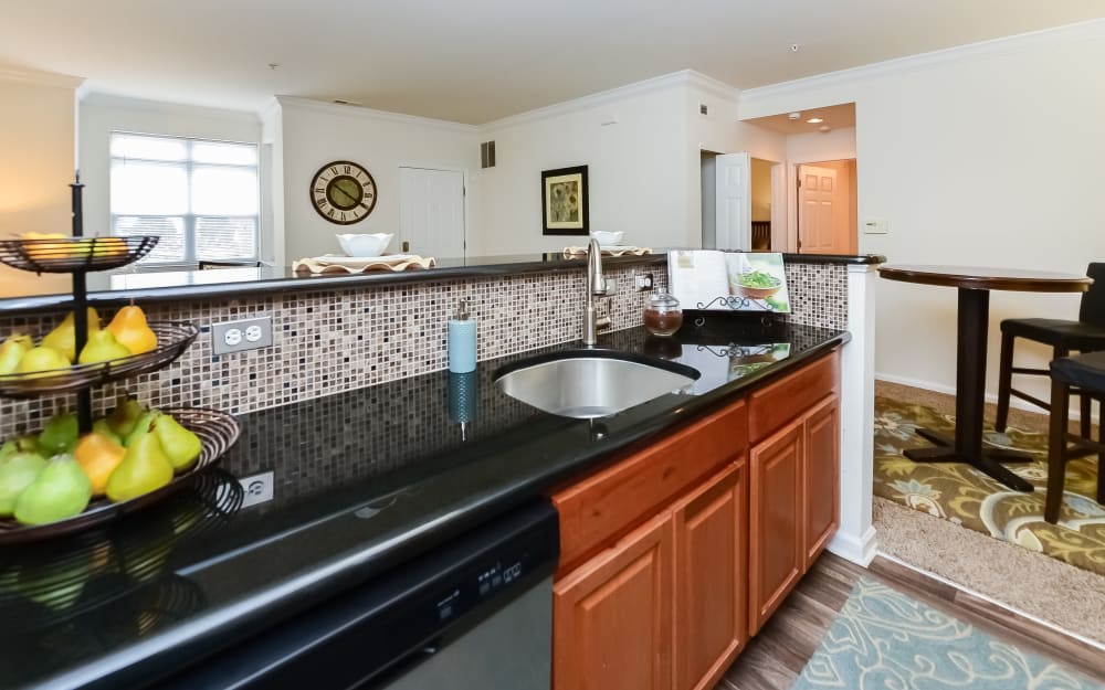 Model kitchen with stainless-steel appliances and tile backsplash at Bishop's View Apartments & Townhomes in Cherry Hill, New Jersey