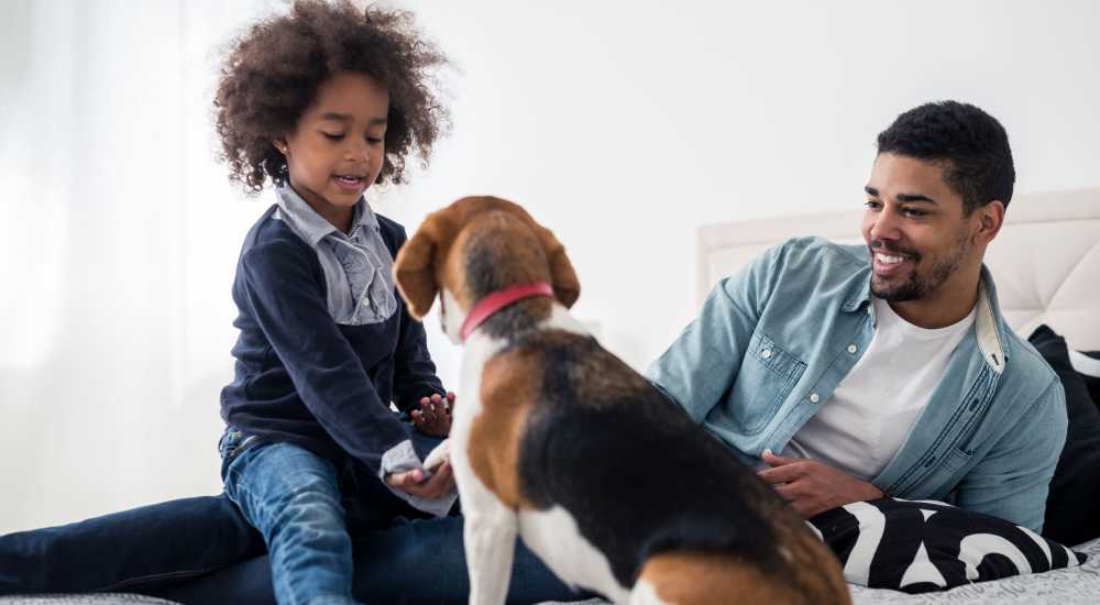 A resident man with his son and pet dog in his apartment home at Terraces at Suwanee Gateway in Suwanee, Georgia