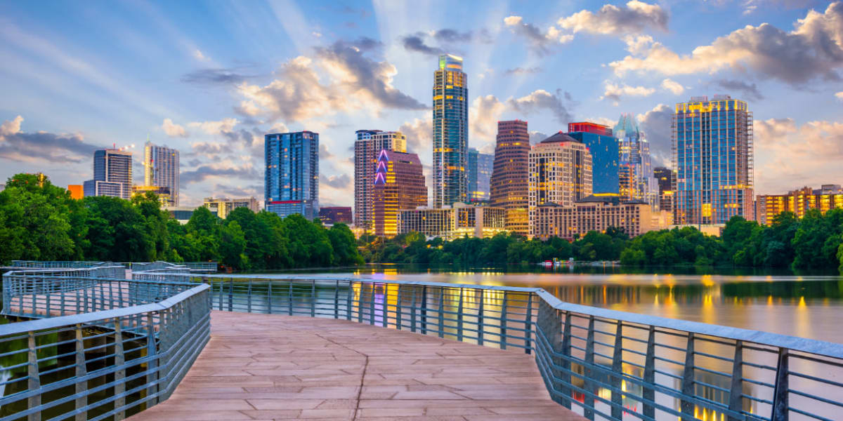 Light rays shooting out behind downtown Austin skyline near Marquis at Barton Trails in Austin, Texas