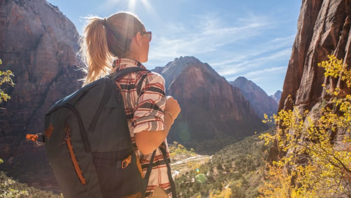 Woman hiking and resting on top of a valley
