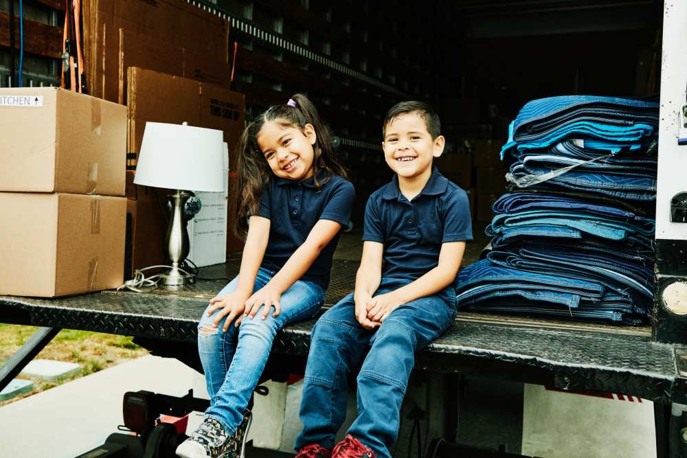 Two kids sitting at the back of a truck from Stayton Mini Storage in Stayton, Oregon