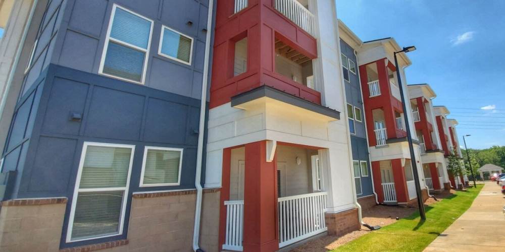 Modern apartment community with colorful exterior, balconies, and well-maintained landscaping at The Mezzanine at Freedom in Charlotte, North Carolina
