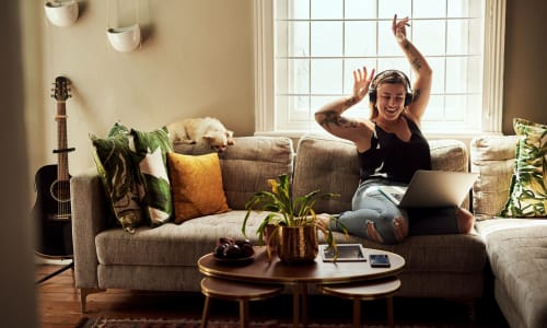 A resident relaxing on her couch in her new apartment at Marina Breeze in San Leandro, California