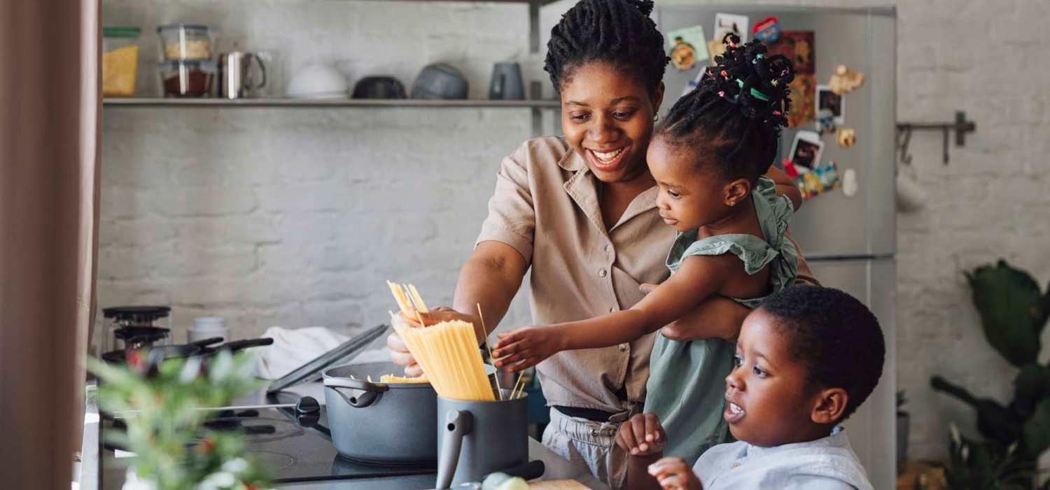 A happy resident family cooking together in their kitchen at Pine Bluff in Kingsford, Michigan