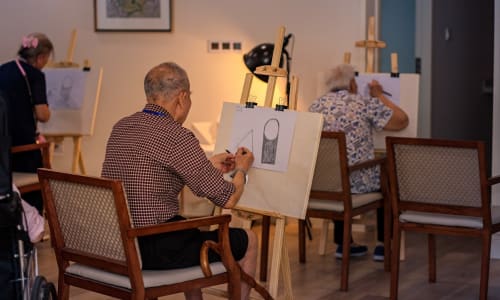 A resident working on a task at a Merrill Gardens china community