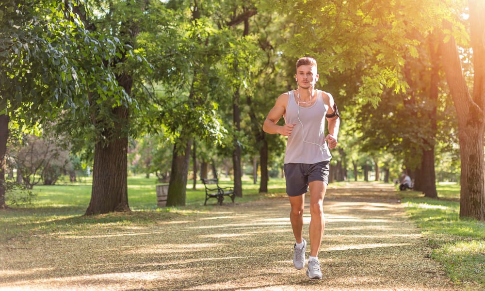 Resident on a morning jog through a tree-lined park near Oaks Lincoln Apartments & Townhomes in Edina, Minnesota