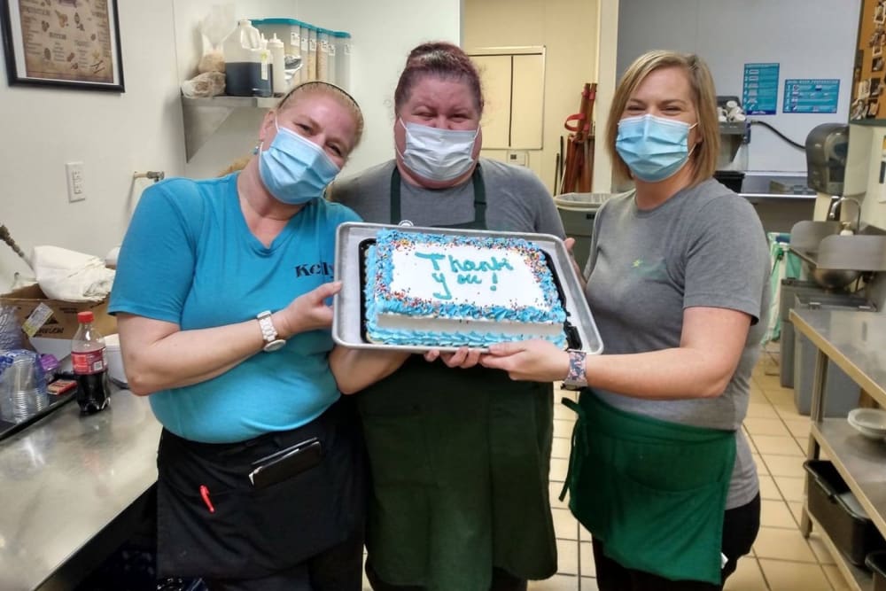 Staff members presenting a birthday cake at English Meadows Laurens Campus in Laurens, South Carolina