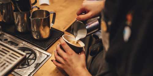 Barista pouring latte art into a coffee cup at a cafe at Northgate Meadows Apartments in Cincinnati, Ohio