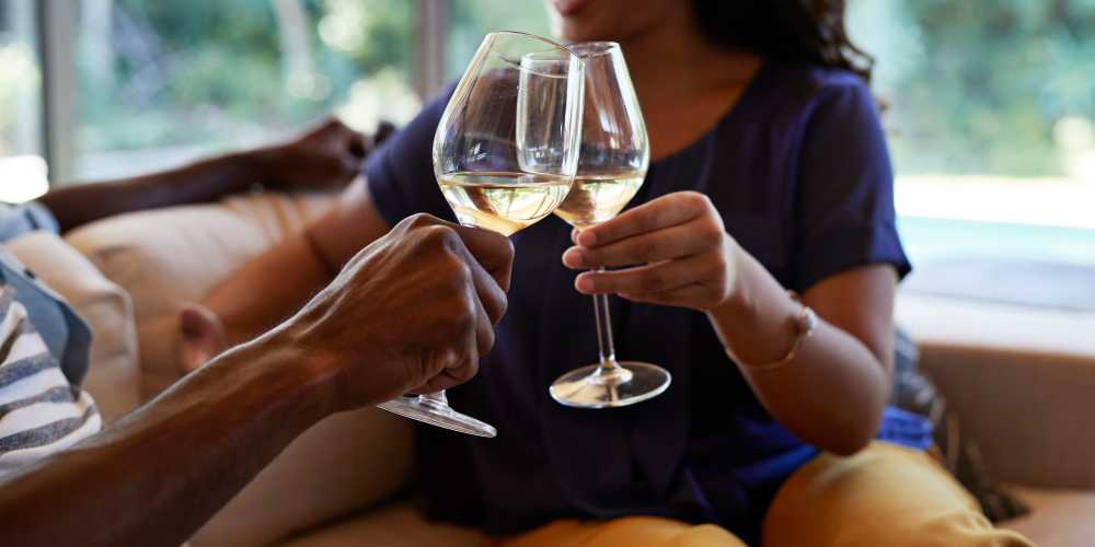 A couple toasting wine glasses at Hamlet at MidCity in Huntsville, Alabama