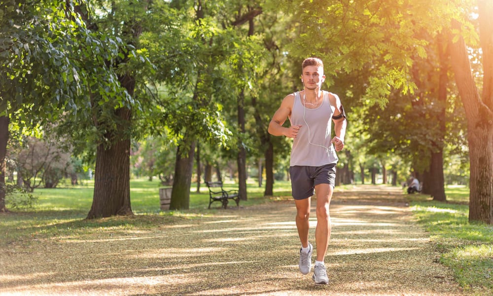 Resident going for a morning jog through a wooded park near Oaks Station Place in Minneapolis, Minnesota