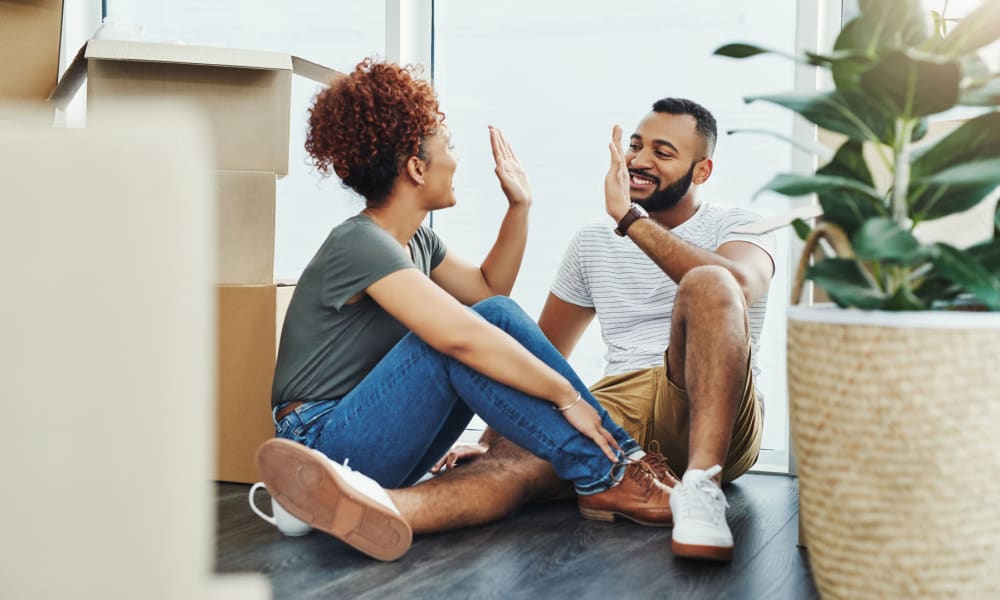 Resident couple high-fiving each other while taking a break from moving in to a community by Mission Rock at Marin in San Rafael, California