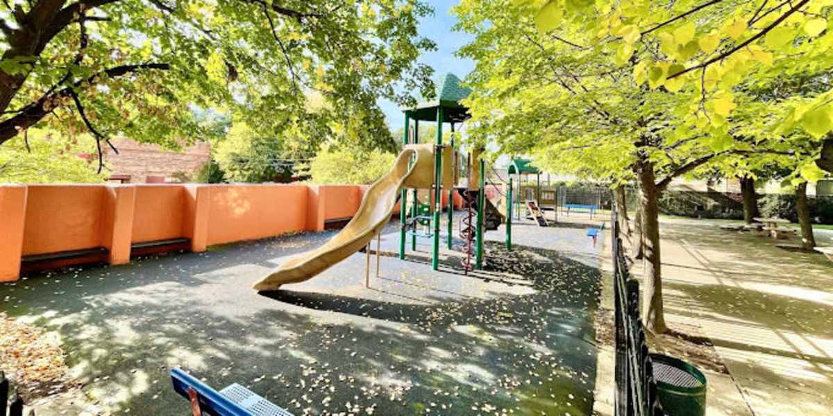 Playground surrounded by leafy trees at Capitol Green in Albany, New York
