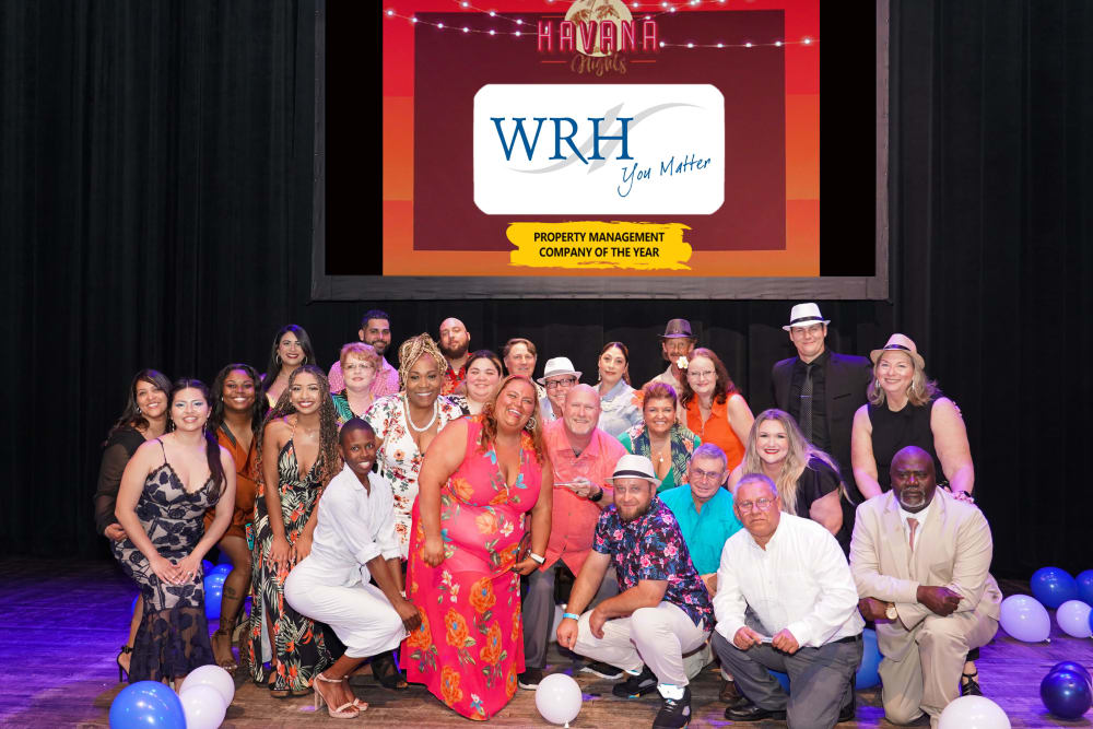A group of staff members on stage representing  WRH Realty Services, Inc 