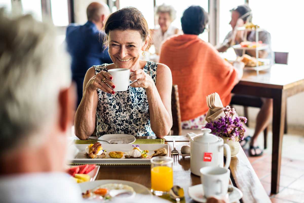 Resident eating breakfast with a friend at Keystone Place at Beachwalk in Fort Myers, Florida