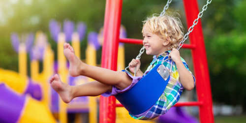 A child on a swing in the play area at Orange Wood Court in Sherman Oaks, California