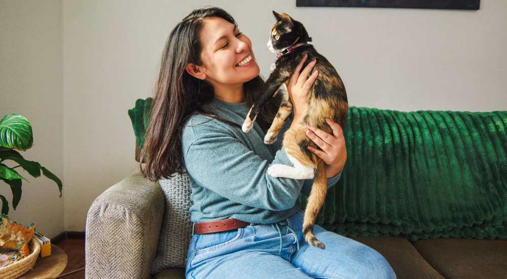 Woman holding cat on couch at Continuum 115 in Mooresville, North Carolina