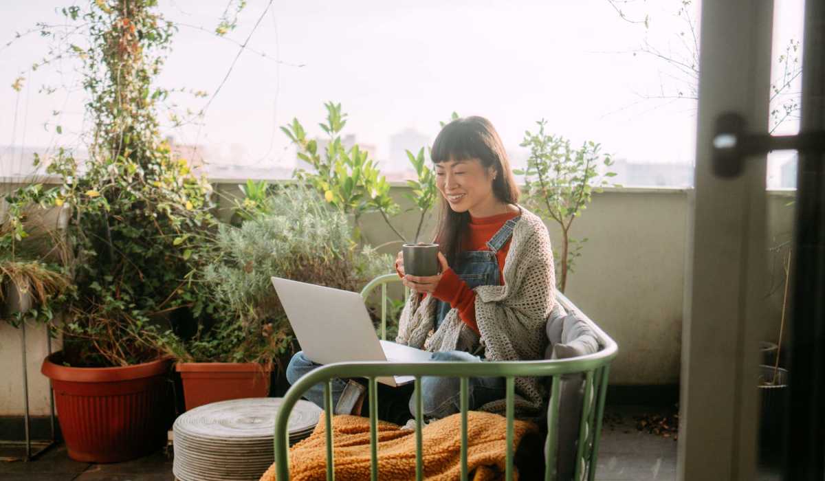 Woamn working on laptop in her private patio at Emerald Place in Lancaster, Ohio