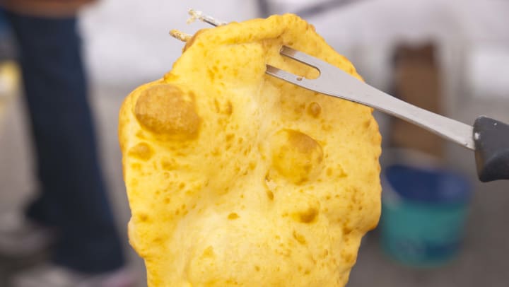 Native American fried bread held onto the fork at Pueblo of Santa Clara near Santa Fe, New Mexico