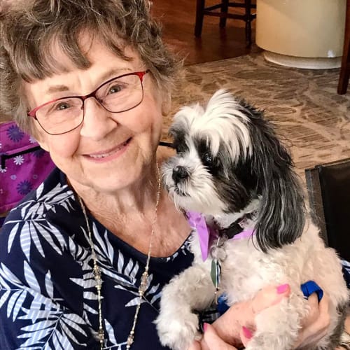 A happy resident sitting inside of The Oxford Grand Assisted Living & Memory Care in McKinney, Texas