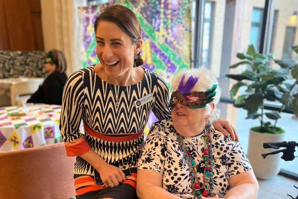 A woman in a colorful dress and mask sits beside an older woman at The Barclay at Charlottesville in Charlottesville, Virginia.