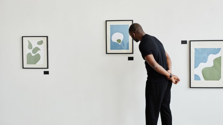 A man looking at a painting in an art gallery in Spring.