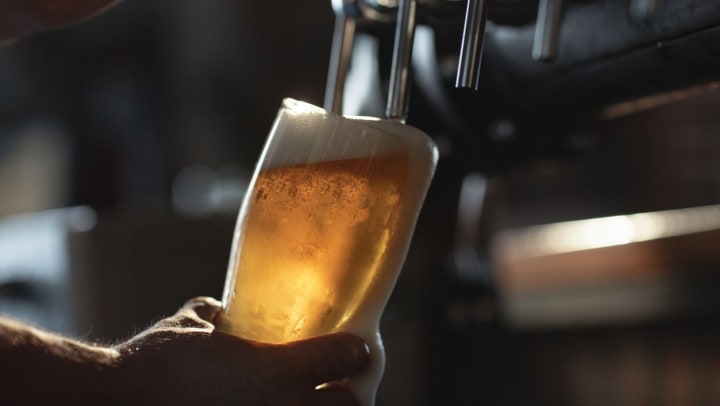 A bartender pours beer into a glass at a Gilbert country bar.