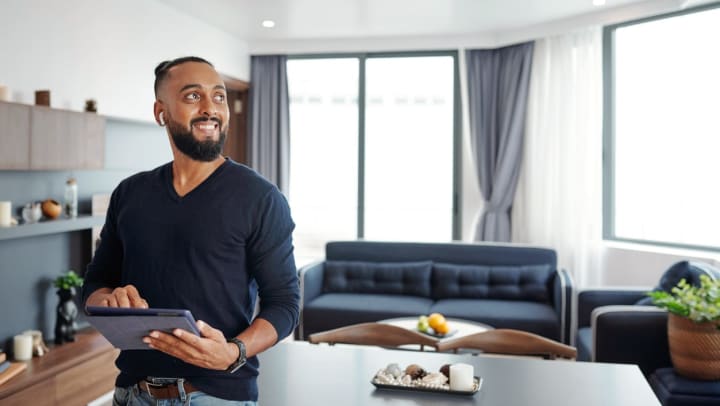 a bearded man using a tablet | tech-savvy apartment trends