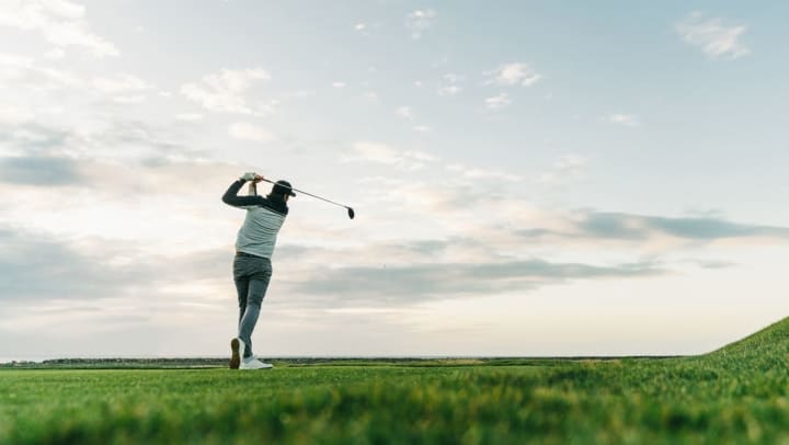 man on golf hitting a perfect tea after practicing at home golf exercises