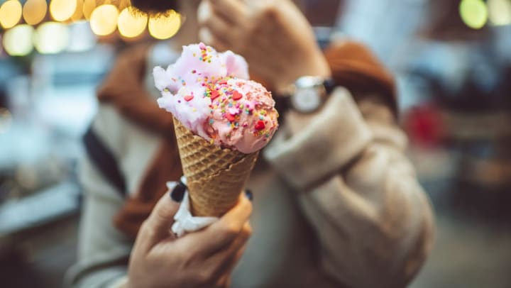 Close-up of a pink ice cream cone with sprinkles