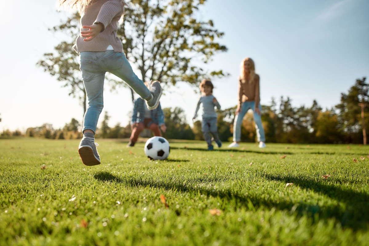 Family playing soccer at a park near The 450 in Lombard, Illinois