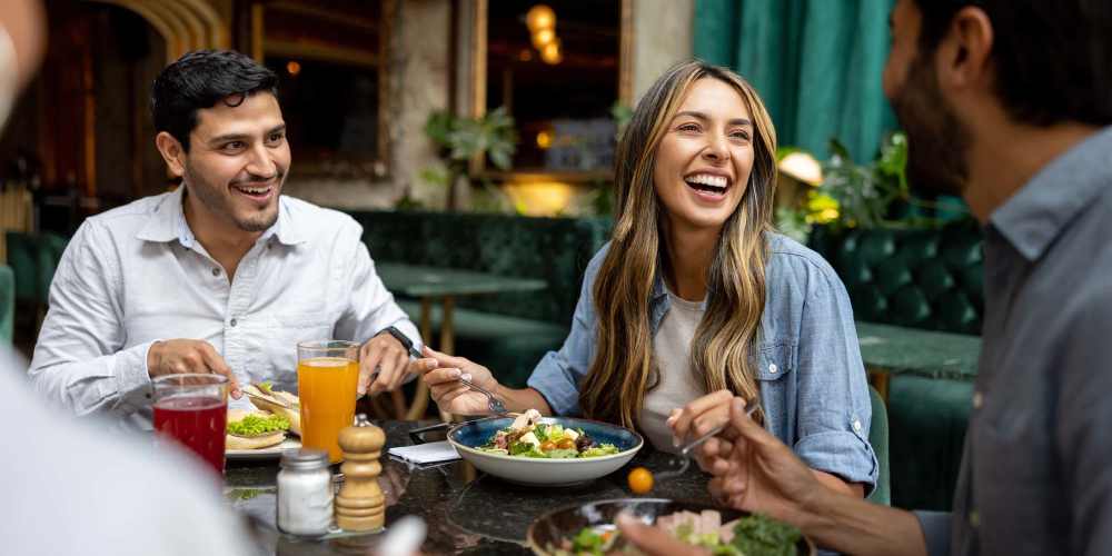 Resident friends enjoying food in a restaurant near One Belmar Place in Lakewood, Colorado