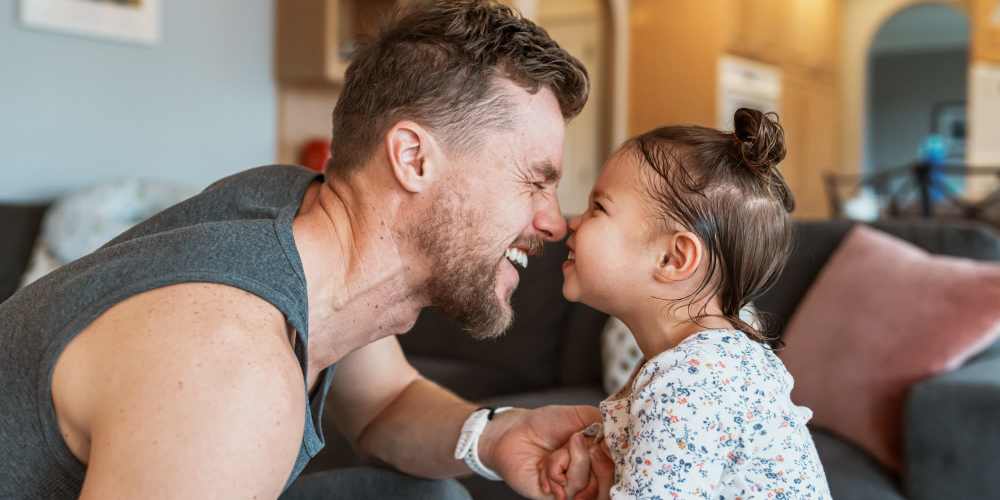 Father and his daughter playing on the living room floor in their apartment at Central West End Apartments in Saint Louis, Missouri