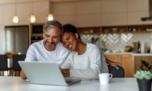 Couple on a laptop in their kitchen at St. Moritz Apartments in Concord, California