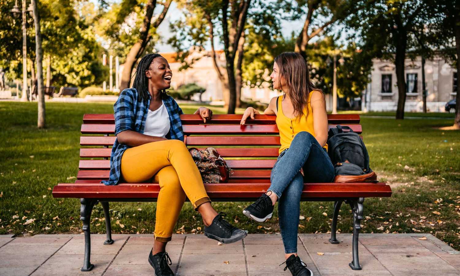 Friends sitting on bench in park near Serenity Apartments in Leesburg, Florida