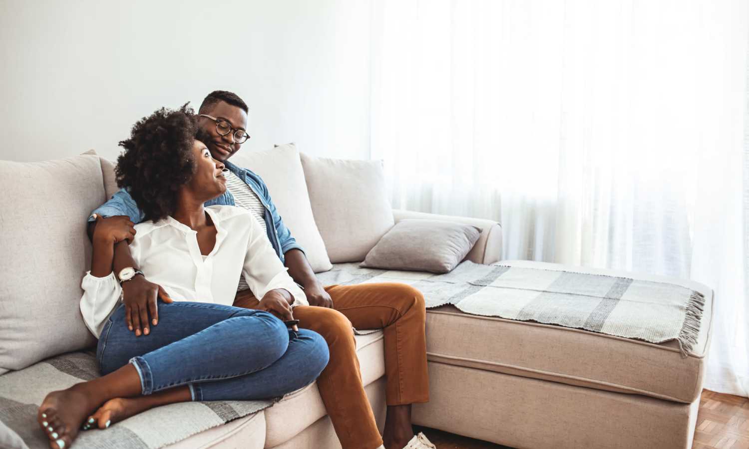 Couple sitting on a light-colored sofa at Ardmore & Twenty Eighth in Atlanta, Georgia 