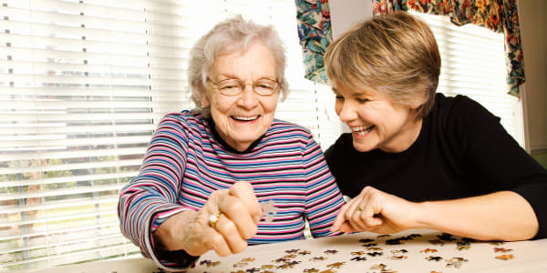 Resident putting together a puzzle with her daughter Montello Care Center in Montello, Wisconsin