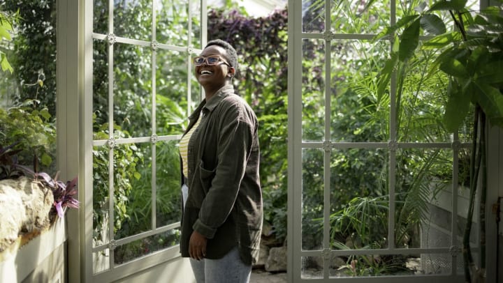 A young women looks around in awe at a botanical garden