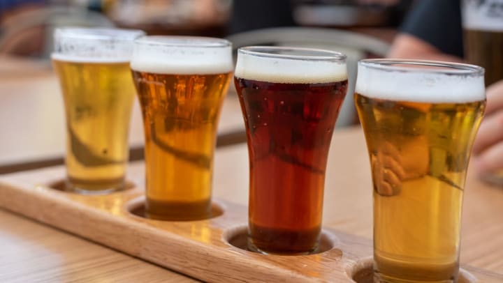 Closeup of a flight of craft beer on an outdoor restaurant table.