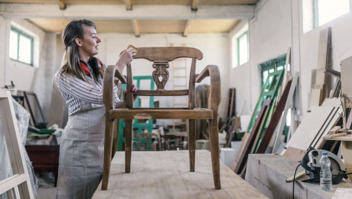 Woman working on repairing a wooden chair | furniture repair shops in Jacksonville