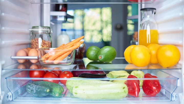 Fruit and vegetables stored in a fridge that is shown from the inside