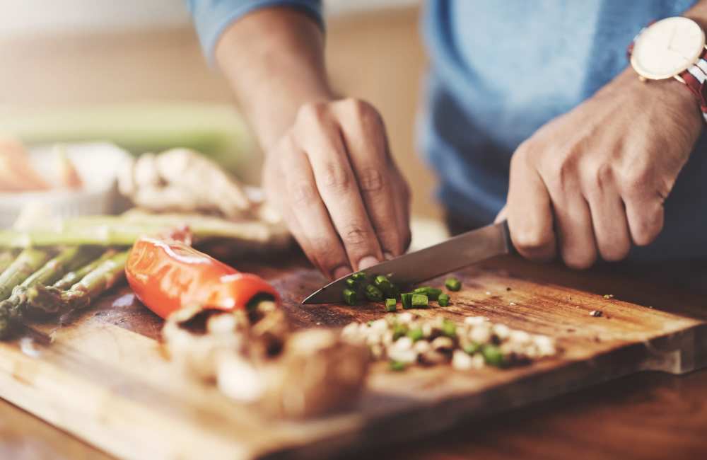 Resident chopping vegetables in his fully equipped kitchen at La Espana Garden in Lodi, California