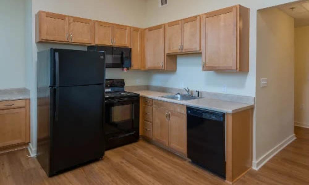 Kitchen with granite countertop and black colored appliances at A.L. Miller Village in Macon, Georgia