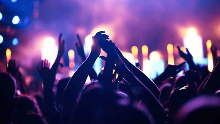 Cheering crowd with hands in the air at a music festival or concert