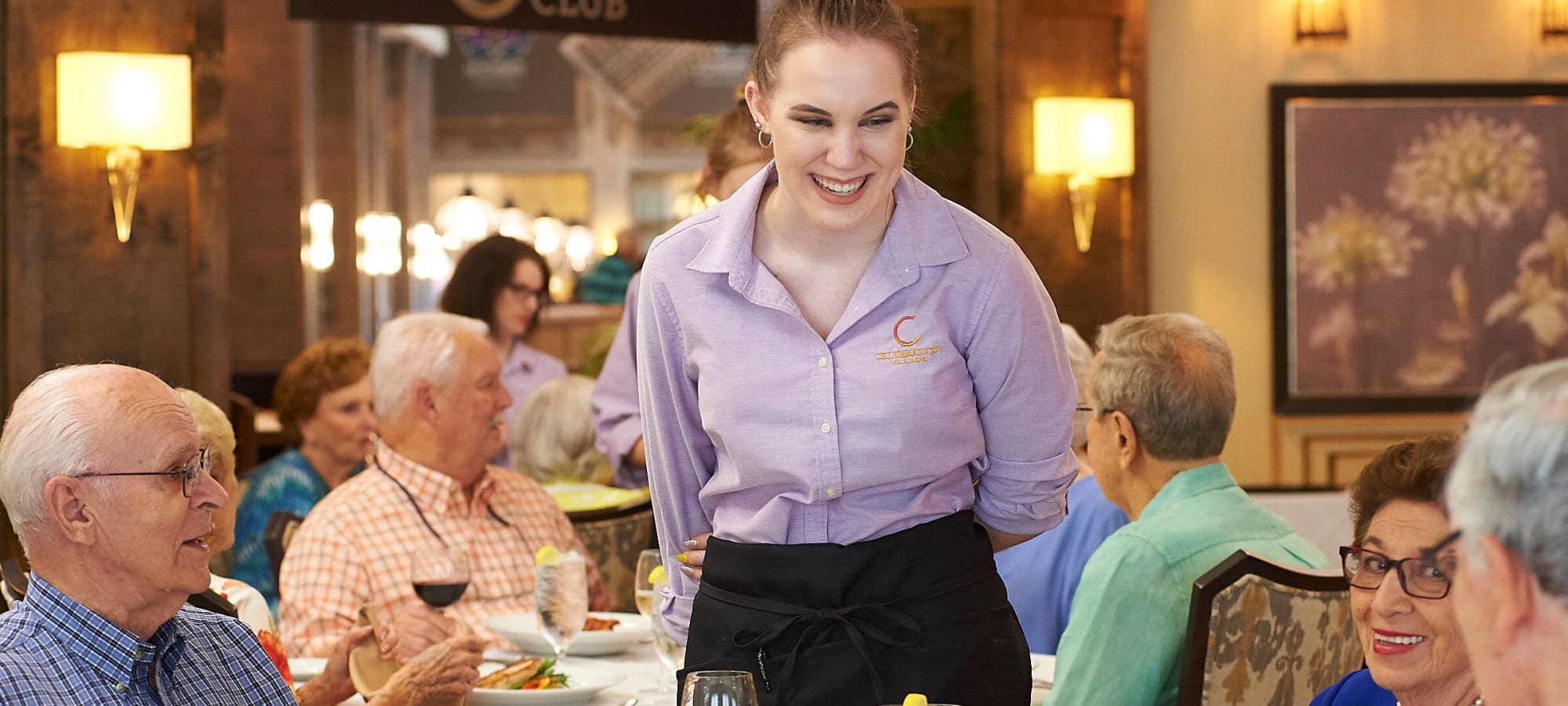 Staff member waiting on residents in the dining room at AgeWell Living