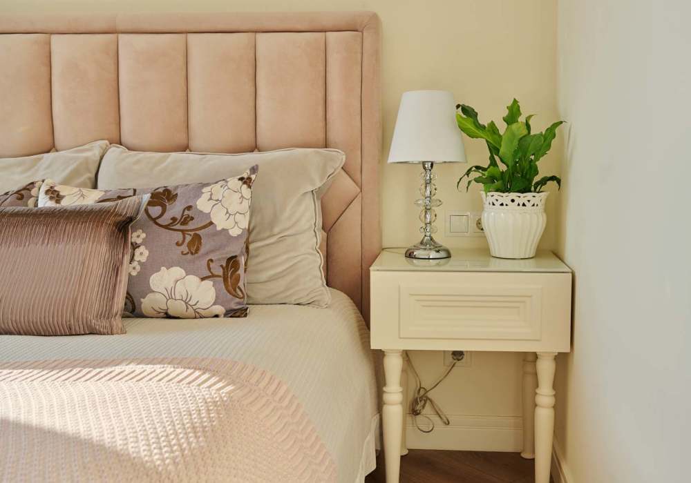 Cozy bedroom with elegant pillows and stylish bedside lamp at Standard at Royal Lane in Dallas, Texas