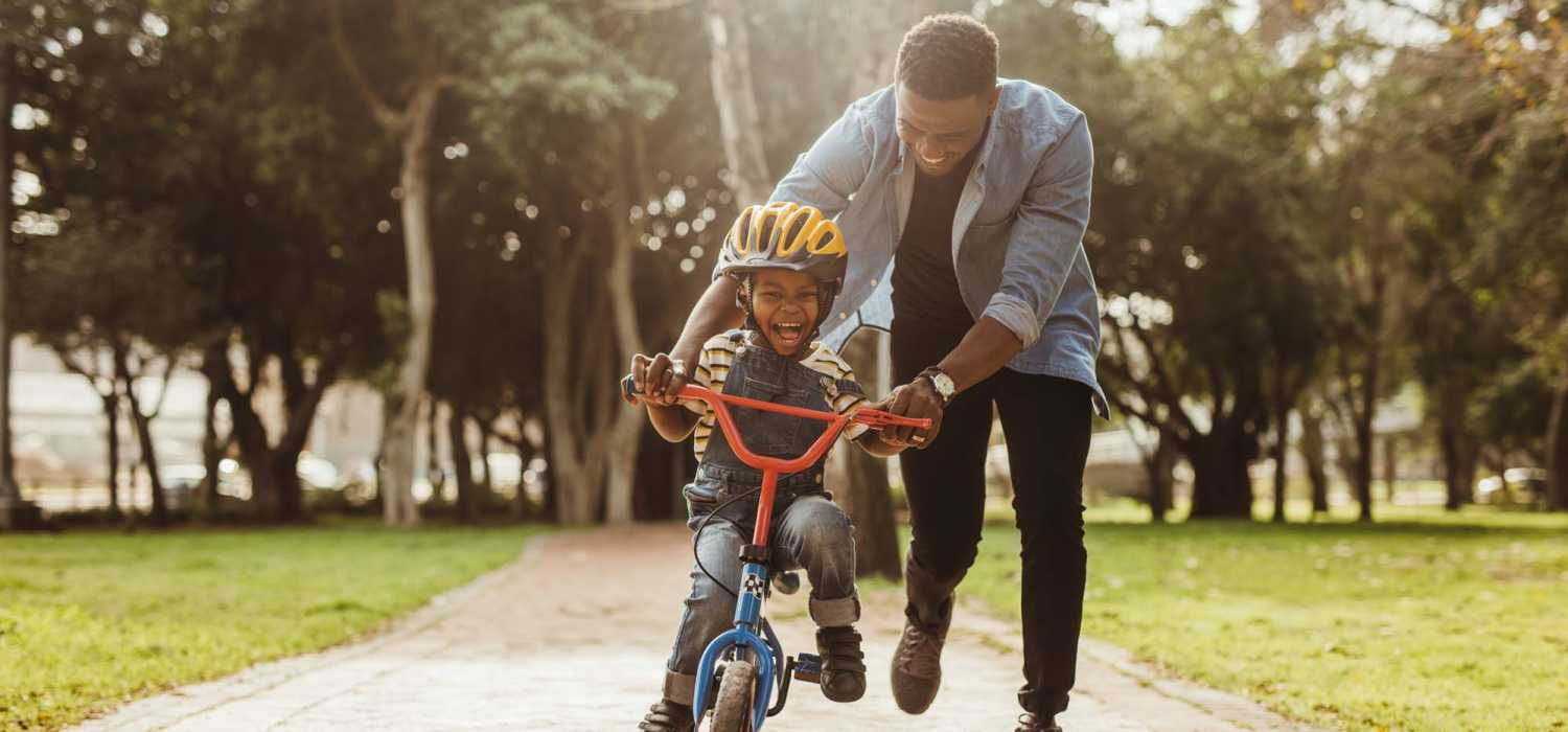 Resident teaching his son to ride bicycle at Amaranth in Candler, North Carolina