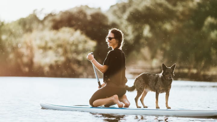 Woman paddleboarding with a dog