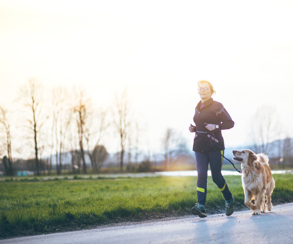 Woman running with a dog in Corpus Christi, Texas near Walnut Ridge Apartments