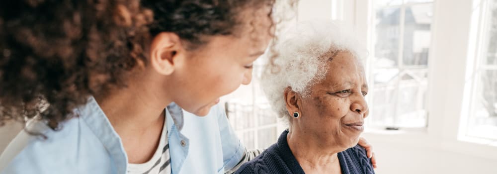 A staff member putting her arm around a resident at a Stoney Brook community