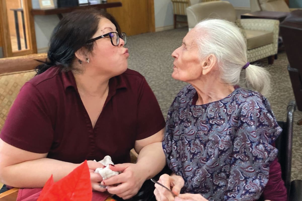 A resident and a caregiver making a silly face at Oxford Vista Wichita in Wichita, Kansas